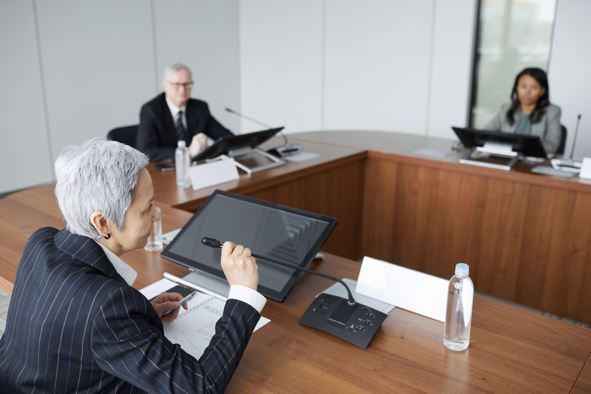 会議室で議論する企業の役員層