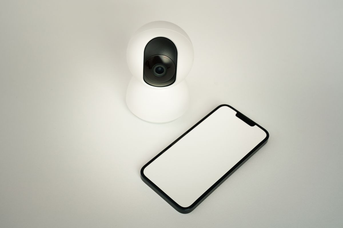 スマート防犯カメラとスマートフォンを並べた写真