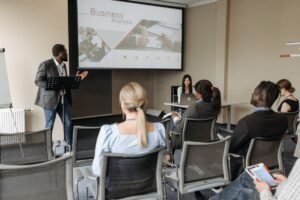 サステナビリティ研修のセミナー会場でスクリーンの説明を聞く受講者たち