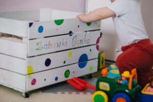 おもちゃサブスクの利用イメージ、色とりどりのおもちゃ箱で遊ぶ子ども