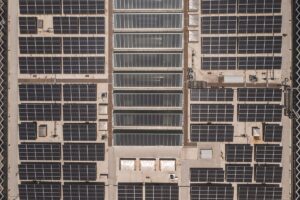 屋上一面に太陽光パネルを設置した工場の俯瞰写真