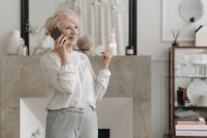 自宅でスマートフォンを使って電話をする高齢の女性