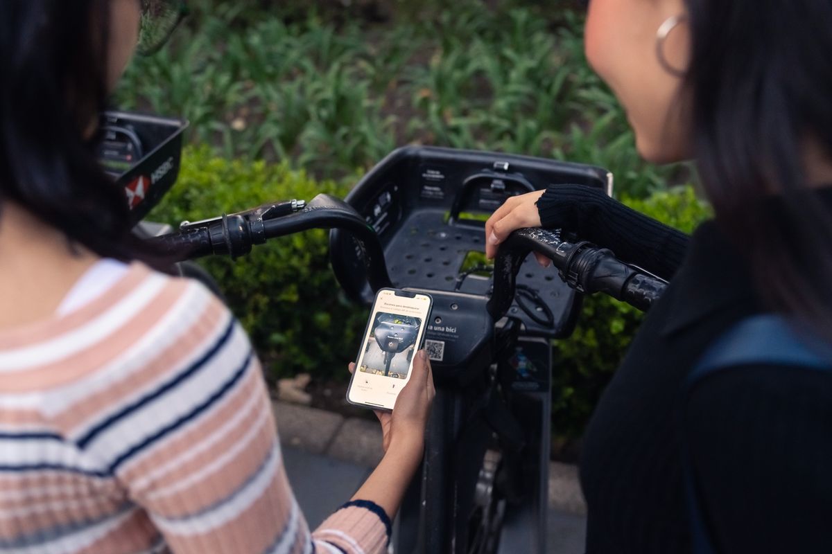 スマートフォンでシェアサイクルの自転車を解錠する利用者