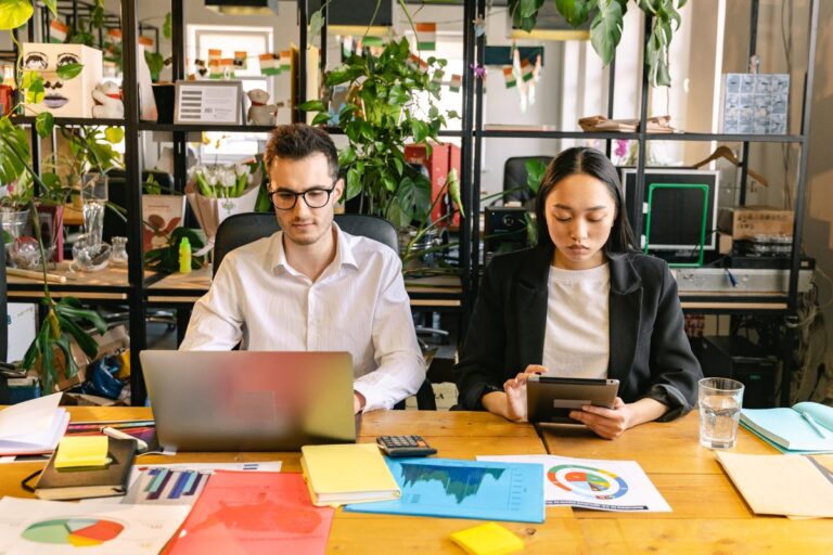 サステナビリティ企業とは何かをイメージする、観葉植物に囲まれたオフィスで働く社員たち