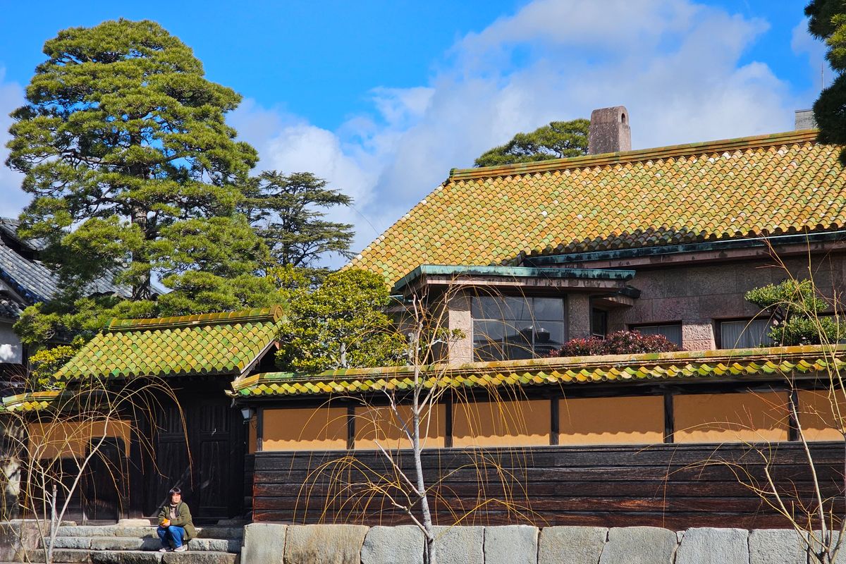 瓦屋根と庭木のある日本の古い家屋の外観