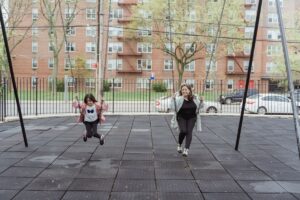 AsMamaの子育てシェアのイメージとして公園のブランコで遊ぶ親子