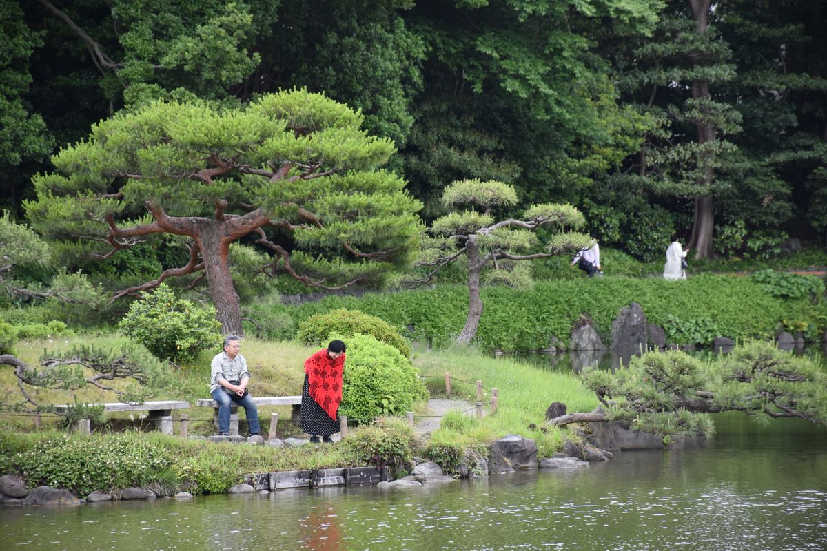 東京の庭園で過ごす高齢の男女