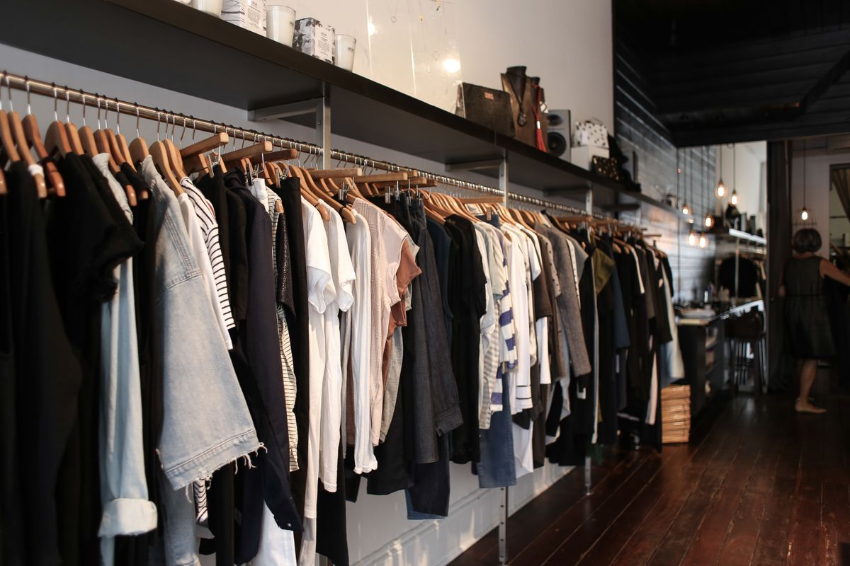 洋服がハンガーに並んだ衣料品売場の様子
