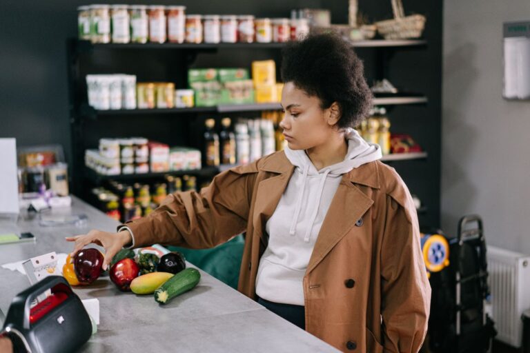 野菜を手に取って買い物をする女性
