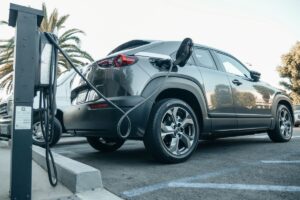 充電ステーションで充電中のグレーの電気自動車