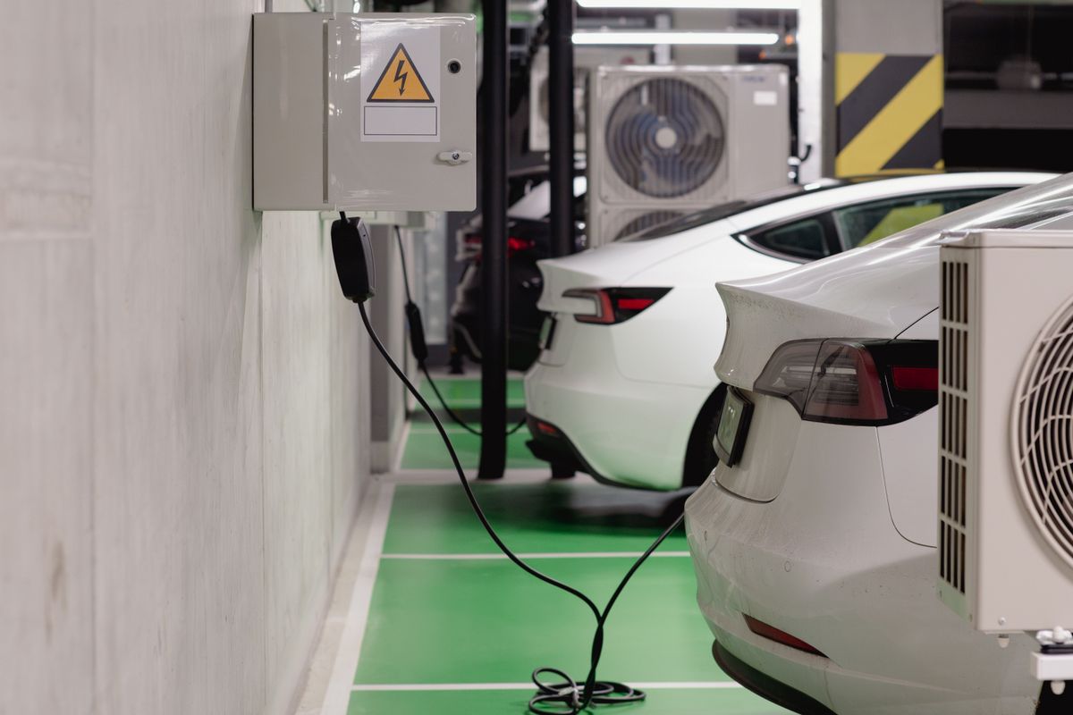 ガレージの充電スペースで充電する白い電気自動車
