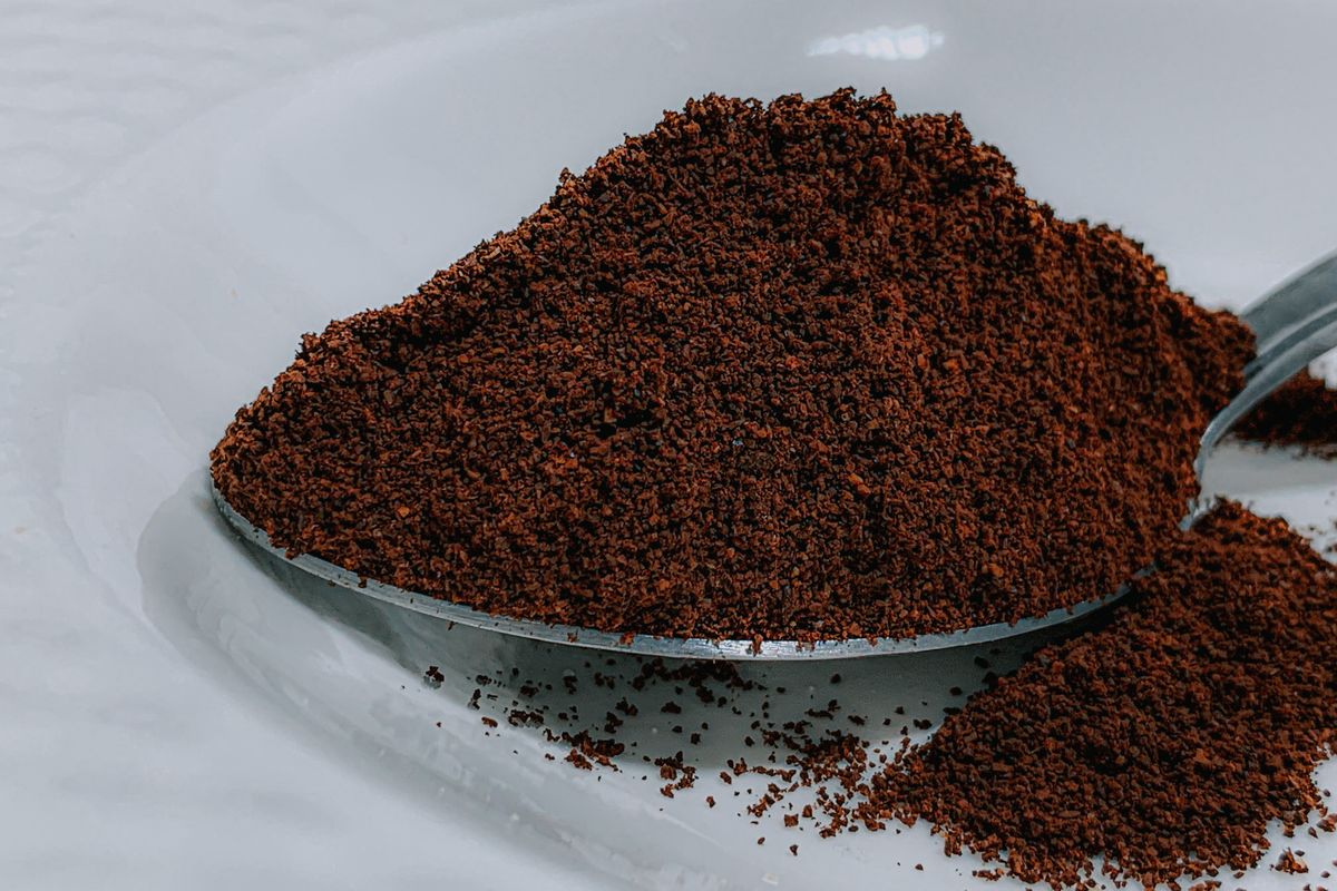 スプーンに山盛りになった挽いたコーヒー粉のアップ