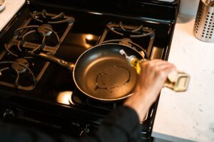フライパンに食用油を注ぐ様子。使い終えた食用油の回収を伝える写真