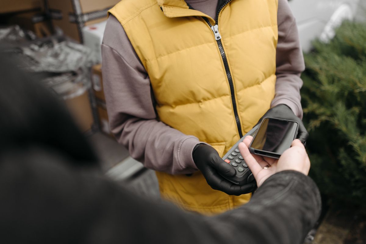 配送スタッフがスマートフォンで支払いを受ける様子