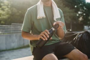 屋外でステンレス製のマイボトルを手にする男性