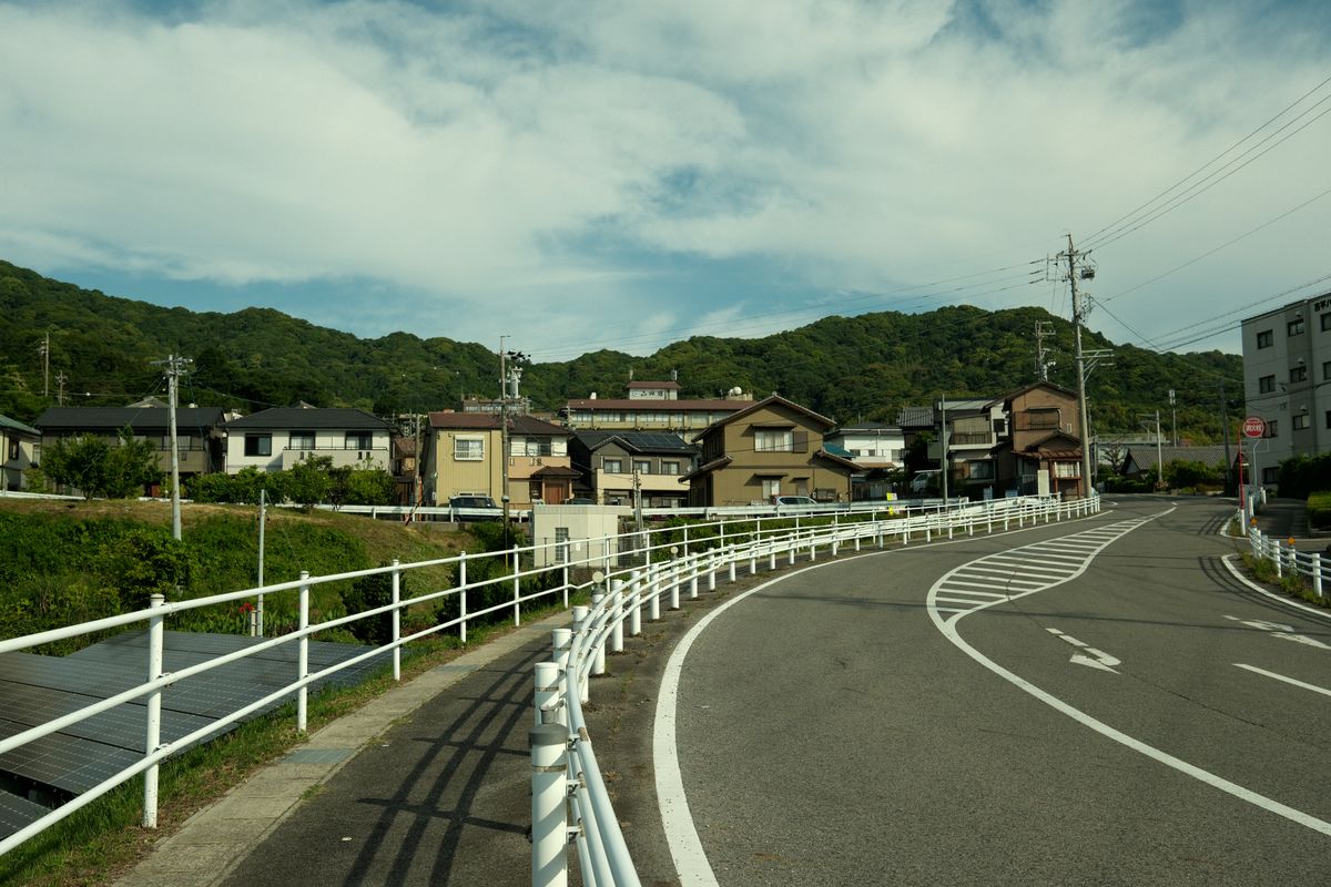 山あいの住宅地を通る地方の道路