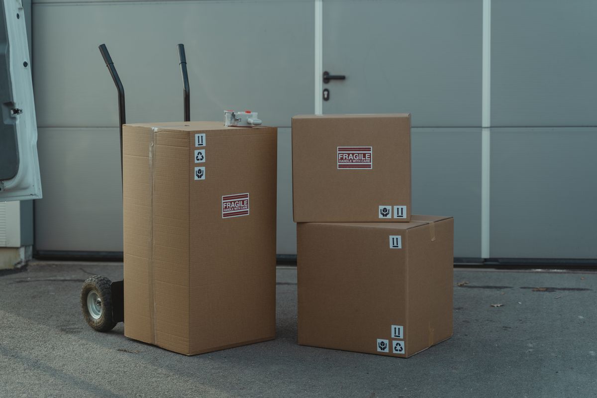 EU向けに出荷する段ボール箱とハンドトラック（PPWRと包装規制のイメージ）