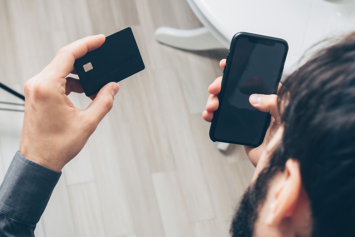 スマートフォンとクレジットカードを手にオンラインで寄付の手続きをする様子