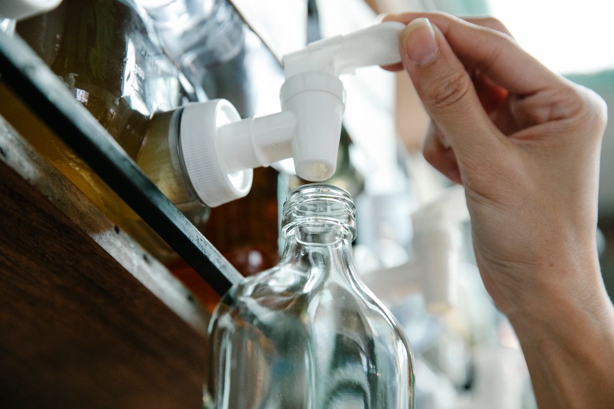 ガラス瓶に給水口から水を入れている手元の様子
