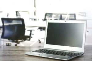 ノートパソコンが置かれたオフィスの机。再生パソコンのイメージ