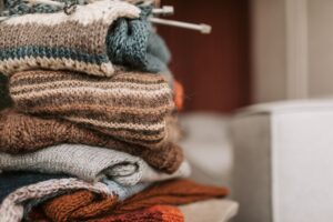 ニットウェアを重ねた山のイメージ。Spiberの素材を使った服のイメージ写真