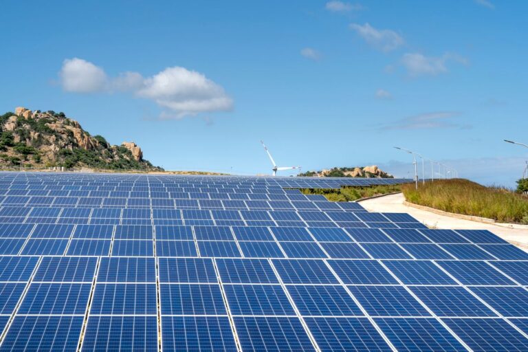 太陽光パネルが並ぶ発電所と風力発電の風景