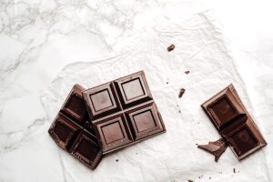 白い大理石の上に置かれた板チョコレートと割れたかけら