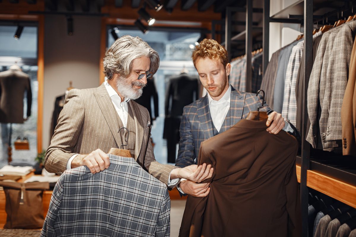 紳士服店でスーツを選ぶ二人の男性